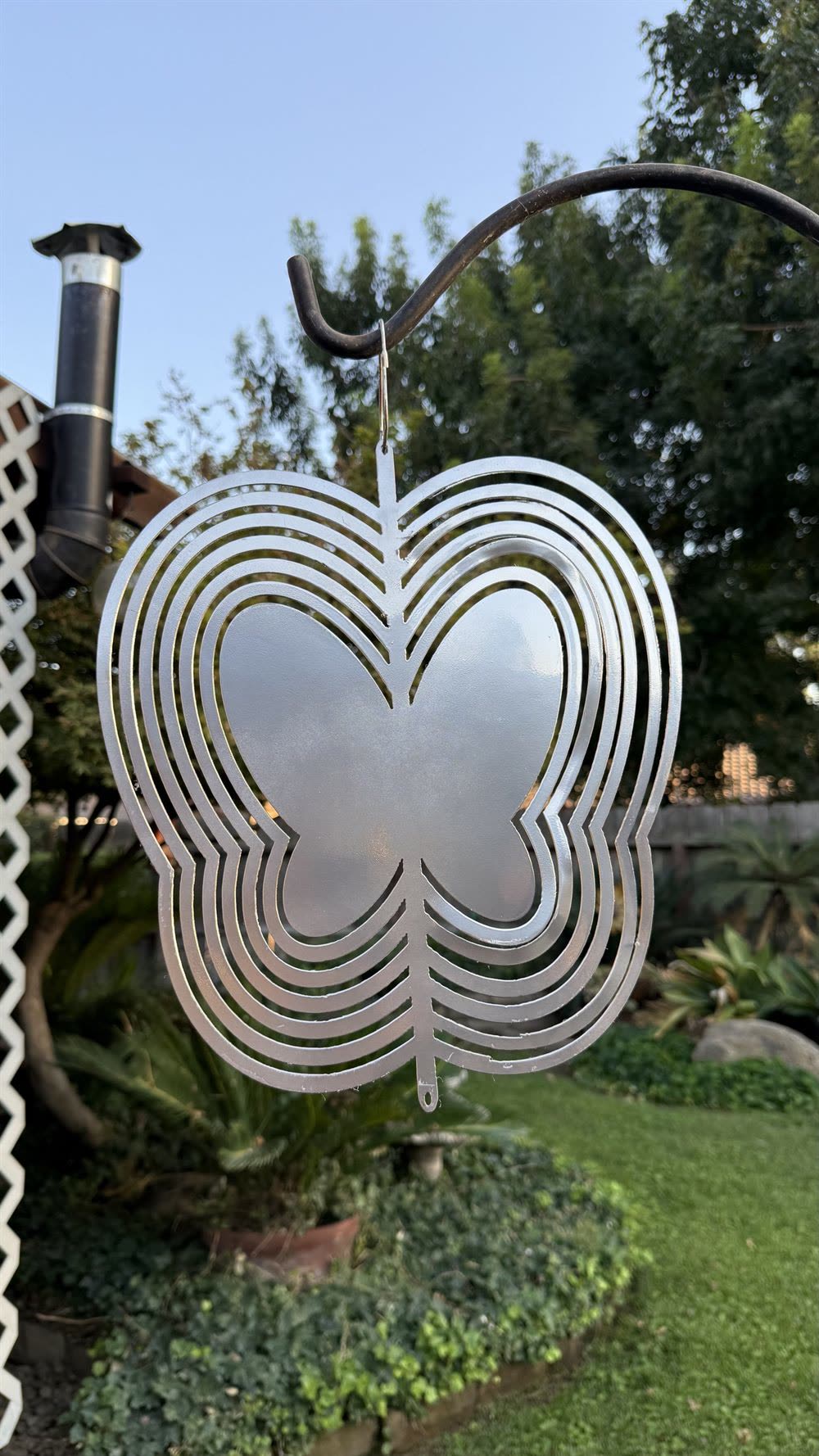 A butterfly-shaped steel wind spinner, shown closed.