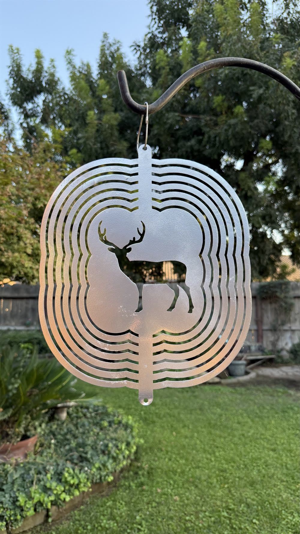 A steel deer wind spinner, shown closed.