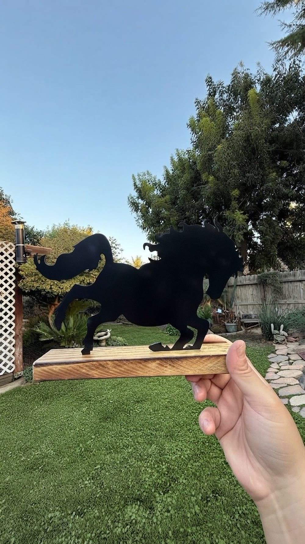 A steel horse silhouette on a wood base.
