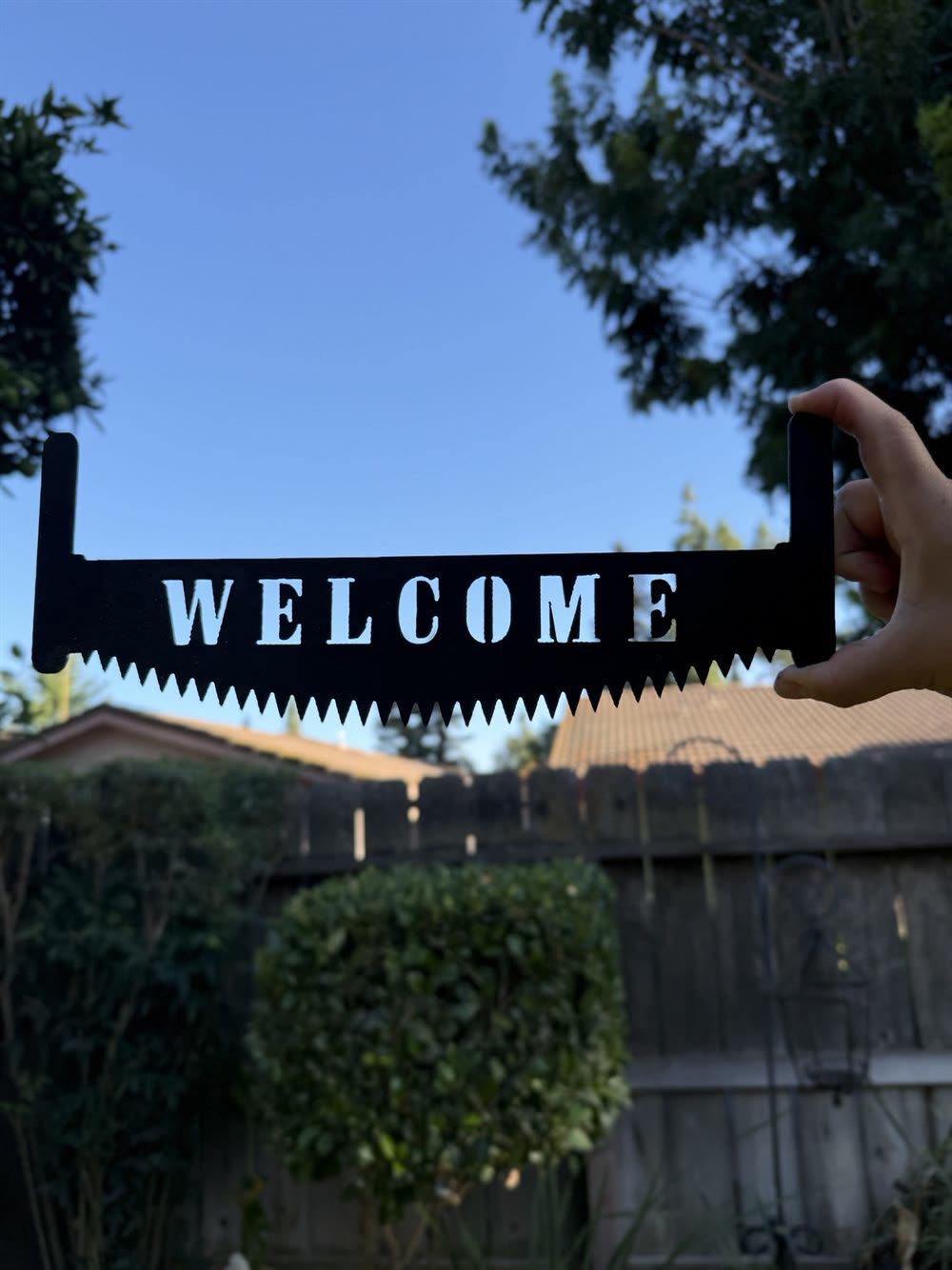 The word Welcome cut through the blade of a two-man saw.
