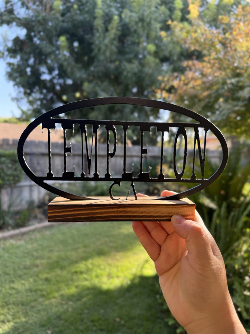 Templeton CA cut inside a steel oval, on a wood base.