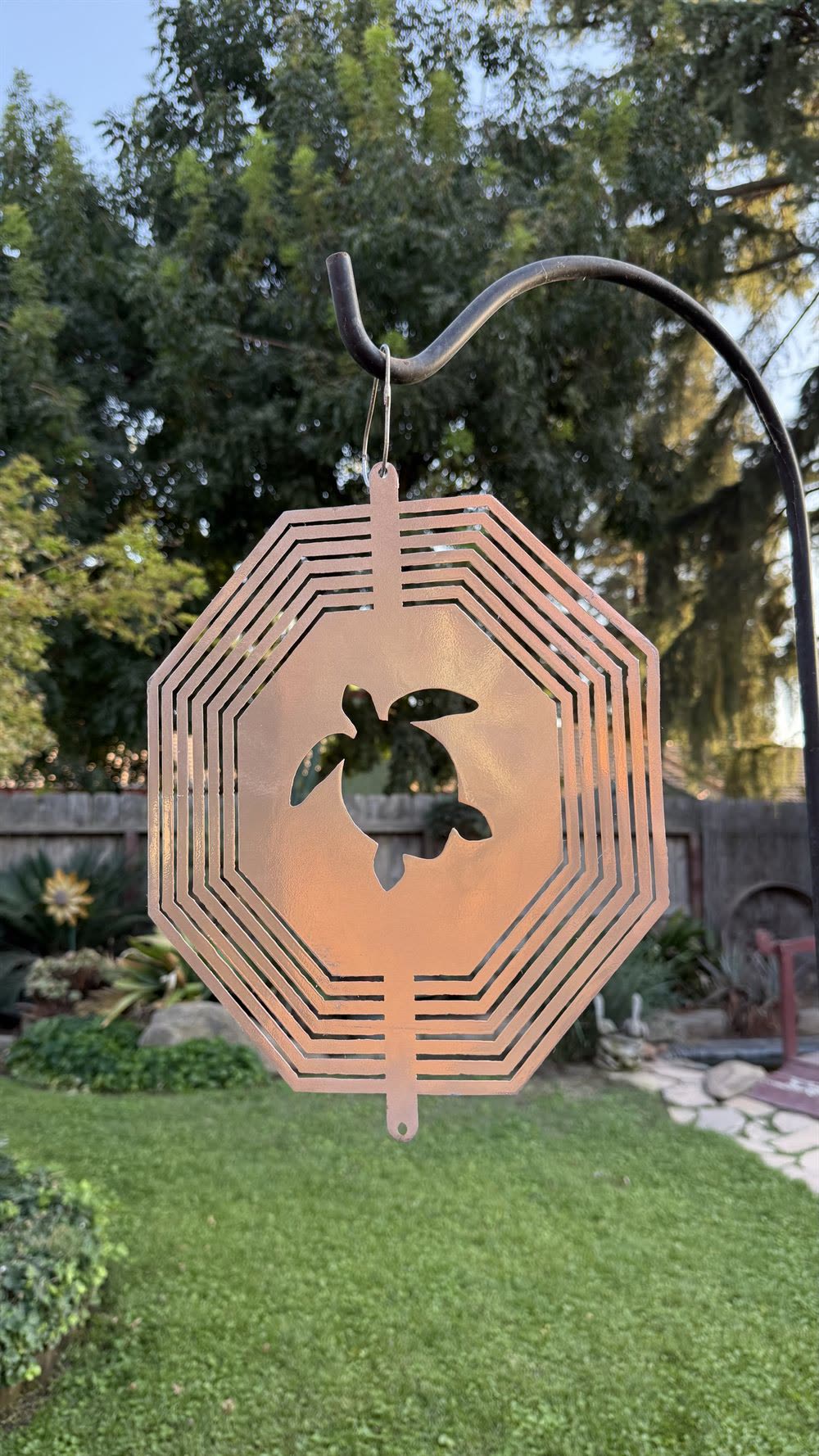A steel turtle wind spinner, shown closed.