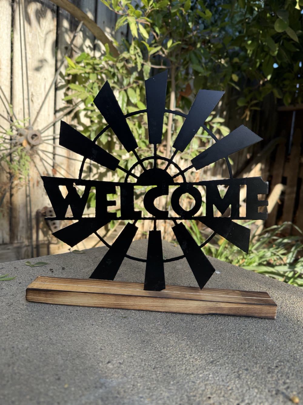 A steel Welcome sign with a windmill behind the letters.
