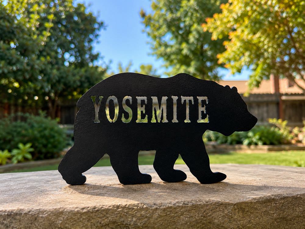 A steel bear with Yosemite cut through it, standing on a rock.
